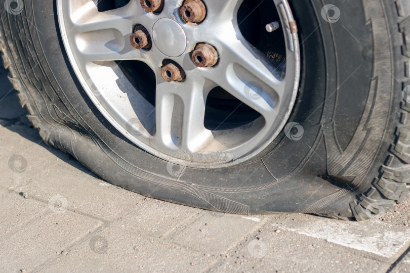 Скачать Спущенная шина на обочине, колесо автомобиля застряло, требуется ремонт фотосток Ozero