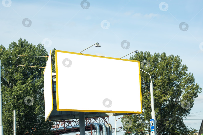 Скачать Белый рекламный щит на фоне неба, усеянного деревьями, прямоугольной формы с травяным фасадом фотосток Ozero