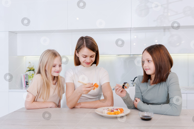 Скачать женщина кормит двух своих дочерей суши фотосток Ozero