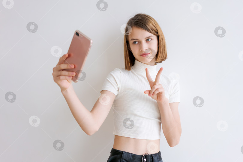Скачать Молодая девушка делает селфи на свой мобильный телефон фотосток Ozero