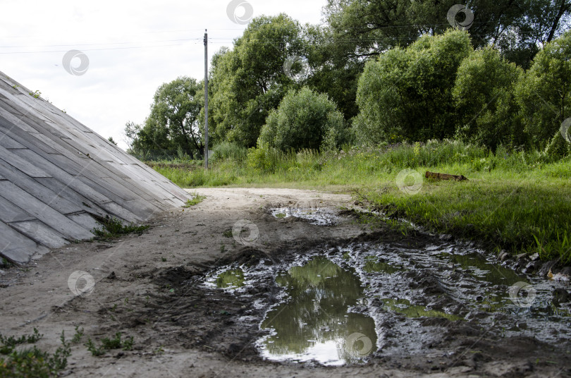 Скачать Лужа на дороге в деревне. Вода - это лужа. фотосток Ozero