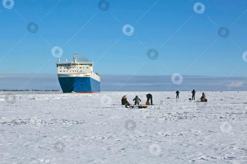 Скачать Контейнеровоз ходит зимой по Финскому заливу.  Рыбаки сидят на льду фотосток Ozero