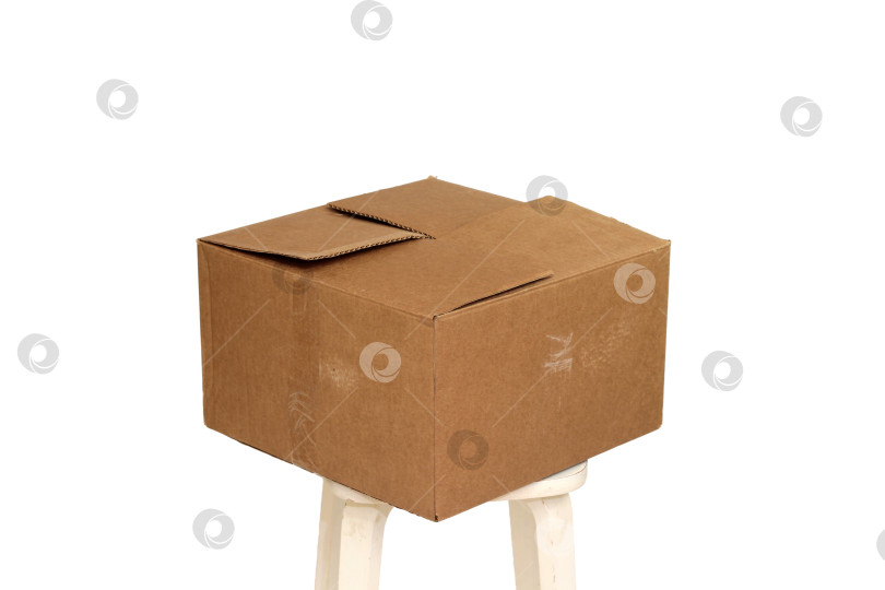 Скачать Прямоугольная картонная коробка на бежевом табурете для творчества и хранения игрушек фотосток Ozero