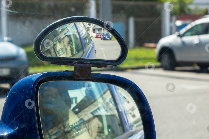 Скачать Синий автомобиль, отражающийся в автомобильном зеркале бокового обзора фотосток Ozero