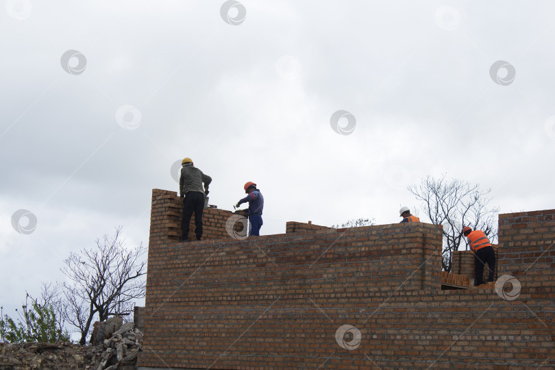 Скачать Строители и кирпичная кладка. Мариуполь. Россия. 5 марта 2024 год. фотосток Ozero