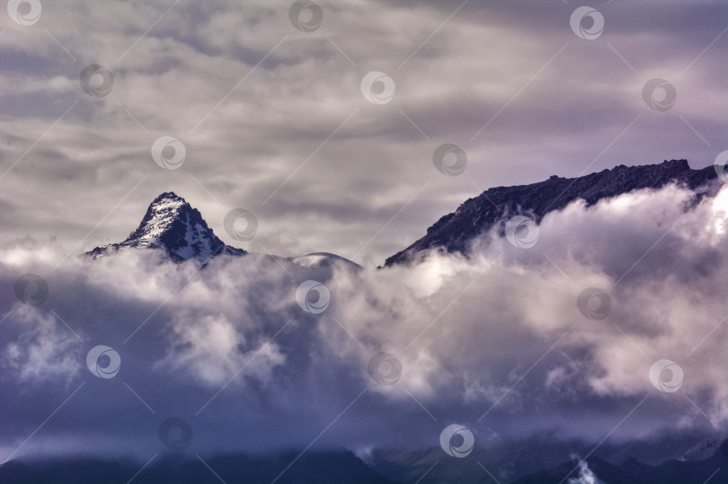 Скачать Снежная вершина горы над грозовыми облаками в Кыргызстане фотосток Ozero