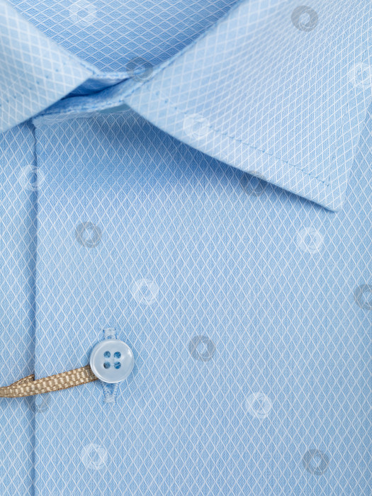 Скачать Крупный план планки на пуговицах на светло-голубой рубашке из сетки в форме ромба фотосток Ozero