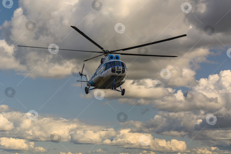 Скачать Вертолет, летящий на фоне облачного неба фотосток Ozero