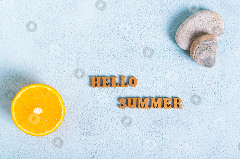Скачать Концепция: надпись "Привет, лето", половинка апельсина и камни на синем фоне, вид сверху фотосток Ozero