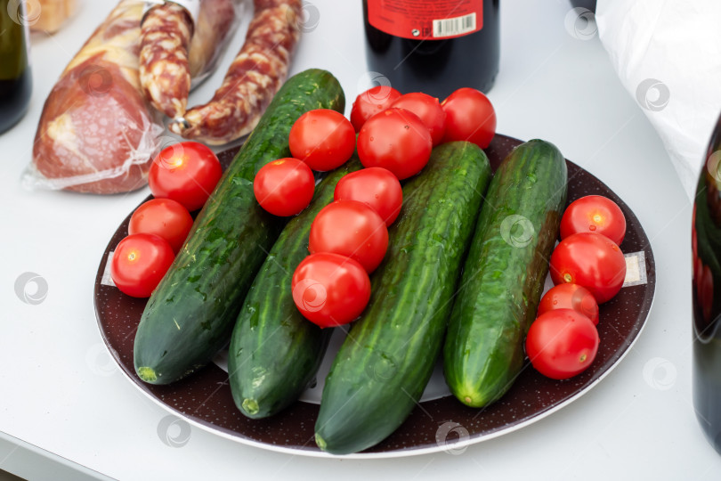 Скачать Тарелка из натуральных продуктов с помидорами черри, огурцами и зеленым луком фотосток Ozero