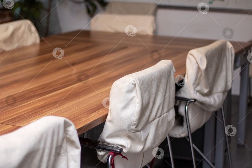 Скачать Удобные белые стулья стоят вокруг деревянного стола на деревянном полу фотосток Ozero