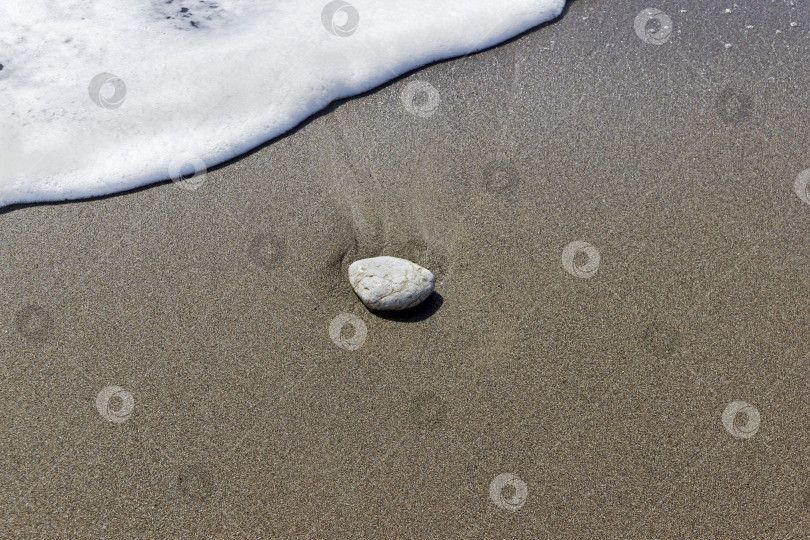 Скачать Одинокий камень на песке в полосе прибоя. фотосток Ozero
