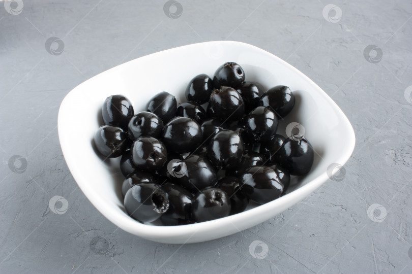 Скачать черные оливки без косточек в миске на столе фотосток Ozero