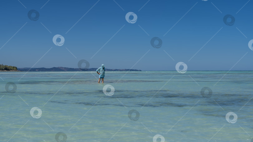Скачать Мужчина стоит по колено в воде. фотосток Ozero