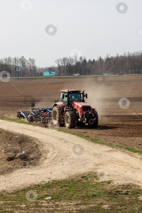 Скачать Красный трактор вспахивает поле крупным планом фотосток Ozero