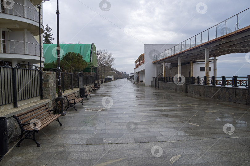 Скачать Пустая набережная в маленьком курортном городке в Крыму. Пасмурно и дождливо. фотосток Ozero