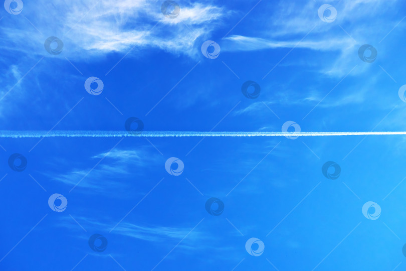 Скачать В голубом небе с перистыми облаками можно увидеть след летящего самолета, естественный фон фотосток Ozero