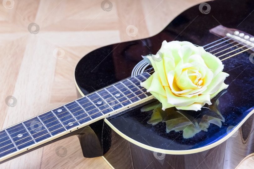 Скачать Акустическая гитара, лежащая на кровати, низкоугольный снимок снизу с медиатором на корпусе фотосток Ozero