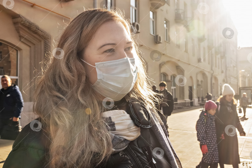 Скачать Портрет молодой женщины в защитной медицинской маске на лице на городской улице. Пандемический коронавирус фотосток Ozero