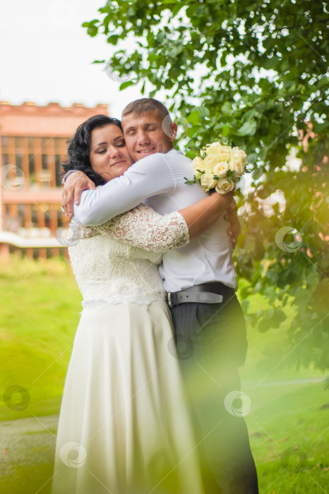 Скачать Жених и невеста крепко-накрепко обнимаются на свадебной фотосессии фотосток Ozero
