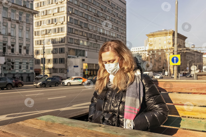 Скачать Портрет молодой женщины в открытом кафе на улице в ожидании заказа. Пандемический коронавирус фотосток Ozero