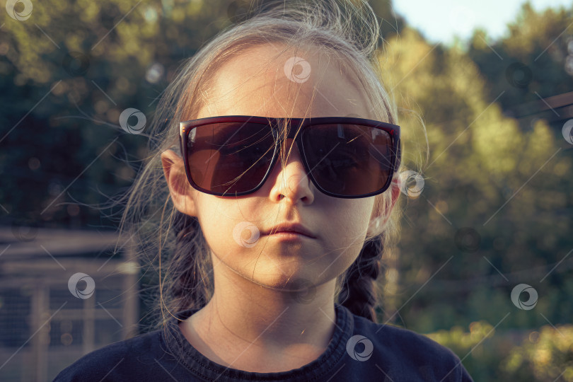 Скачать Девочка в больших солнцезащитных очках. Девушка в очках смотрит прямо, избирательно, в фокусе фотосток Ozero