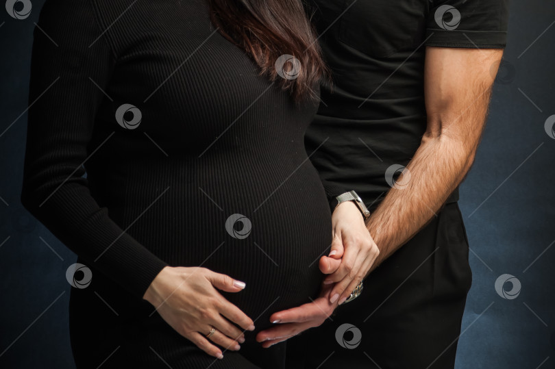 Скачать мужчина и жена в возрасте 40 недель, с большим животом, в черной одежде на белом фоне, стоящие на черном фоне фотосток Ozero