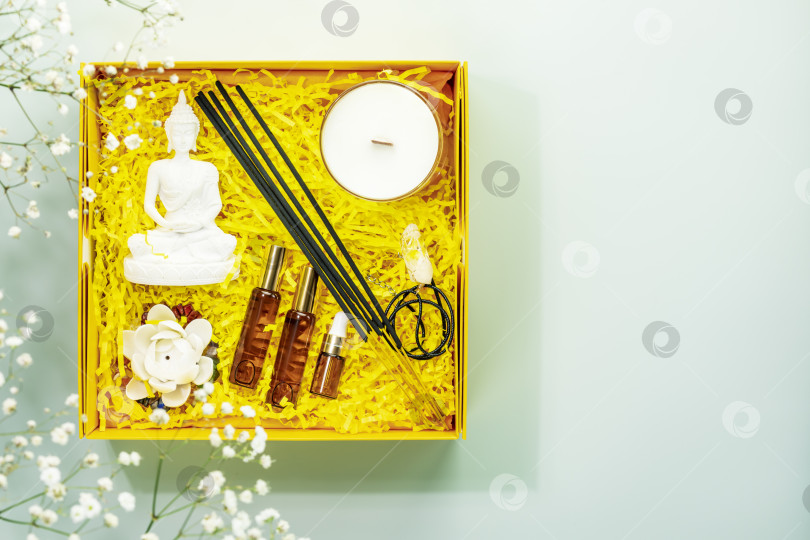 Скачать Желтая подарочная коробка со статуэткой будды, ароматическими палочками, натуральными маслами, свечой, кристаллами фотосток Ozero