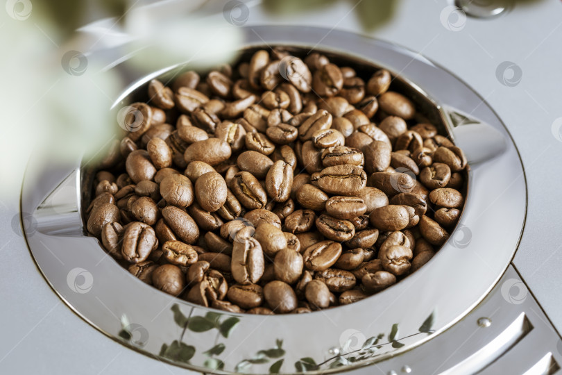 Скачать Натуральные обжаренные кофейные зерна в бункере для зерен, входящем в состав кофемашины фотосток Ozero