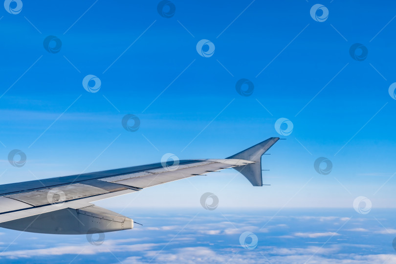 Скачать Прекрасный вид из иллюминатора самолета. голубое небо, облака, земля. фотосток Ozero