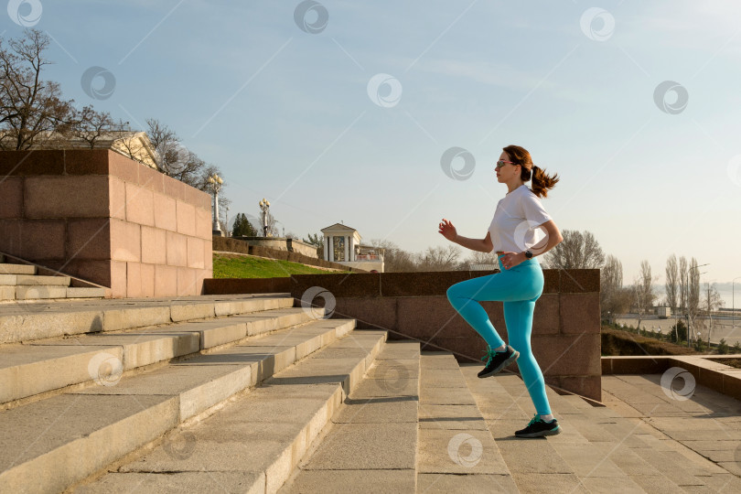 Скачать Молодая женщина бегает трусцой по улицам города фотосток Ozero