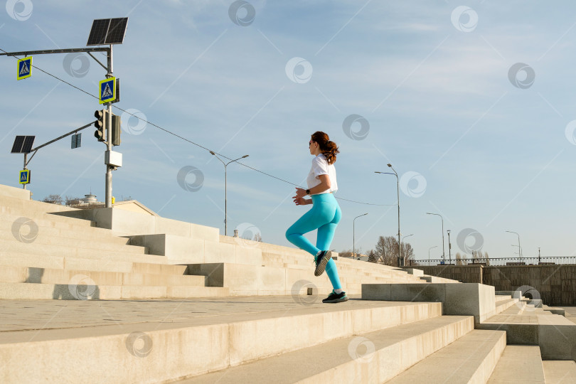 Скачать Молодая женщина бегает трусцой по улицам города фотосток Ozero