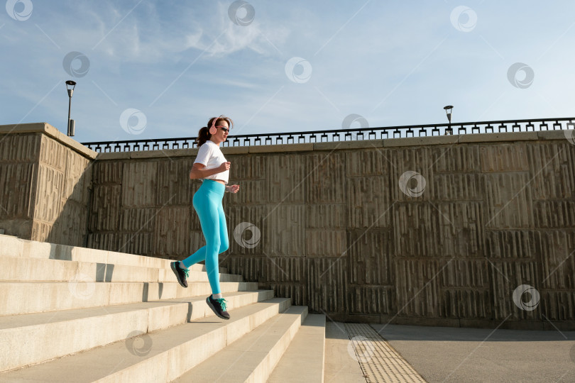 Скачать Молодая женщина бежит по улицам города фотосток Ozero