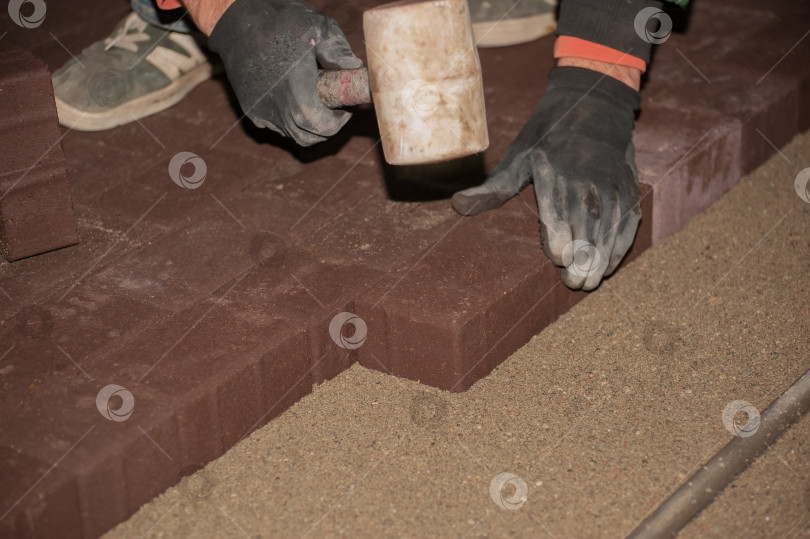 Скачать мужчина печет печенье, укладывая тротуарную плитку фотосток Ozero