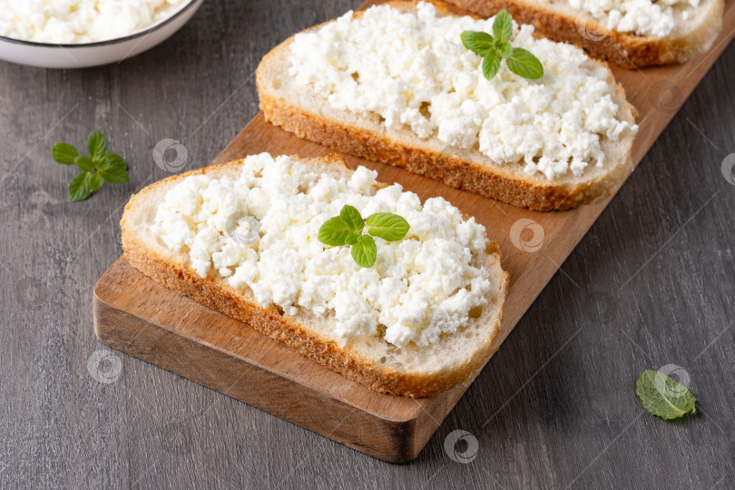 Скачать Хлеб с творожным сыром на сером деревянном столе фотосток Ozero