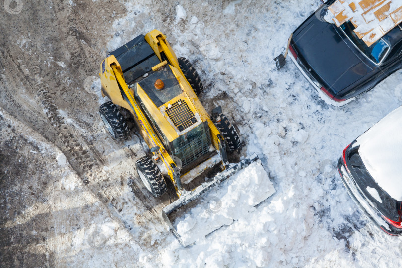 Скачать Вид сверху на снегоуборочную машину, убирающую парковку фотосток Ozero