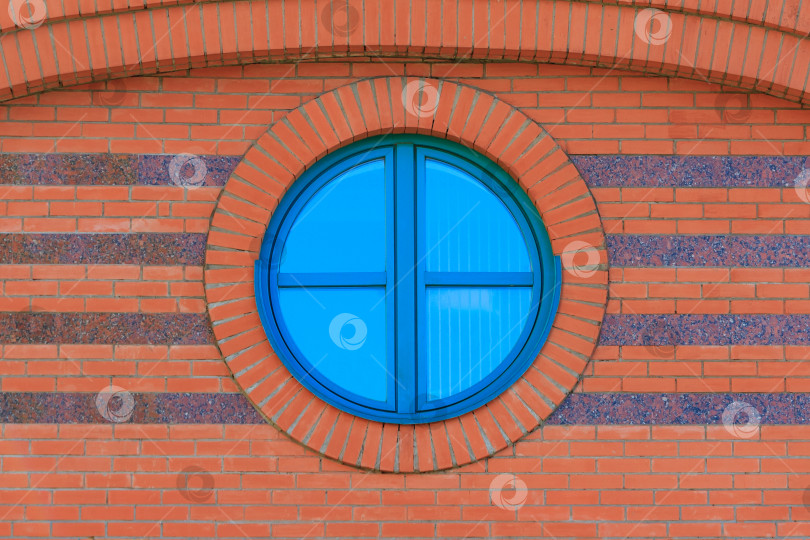 Скачать Стена из красного кирпича с круглым застекленным окном с отражением голубого неба фотосток Ozero