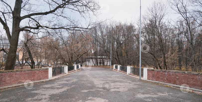 Скачать красивый проход в осеннем парке через мост с кирпичным забором фотосток Ozero