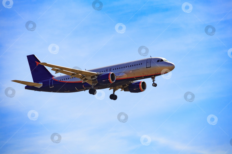 Скачать Темный силуэт пассажирского самолета, летящего в ярко-голубом небе фотосток Ozero