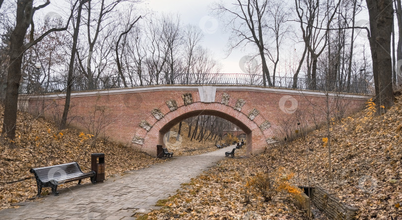 Скачать проход по кирпичному туннелю со скамейками на старинном мосту в городском парке фотосток Ozero