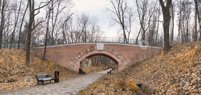 Скачать проход по кирпичному туннелю со скамейками на старинном мосту в городском парке фотосток Ozero
