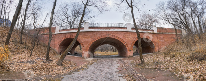 Скачать проход по кирпичному туннелю со скамейками на старинном мосту в городском парке фотосток Ozero