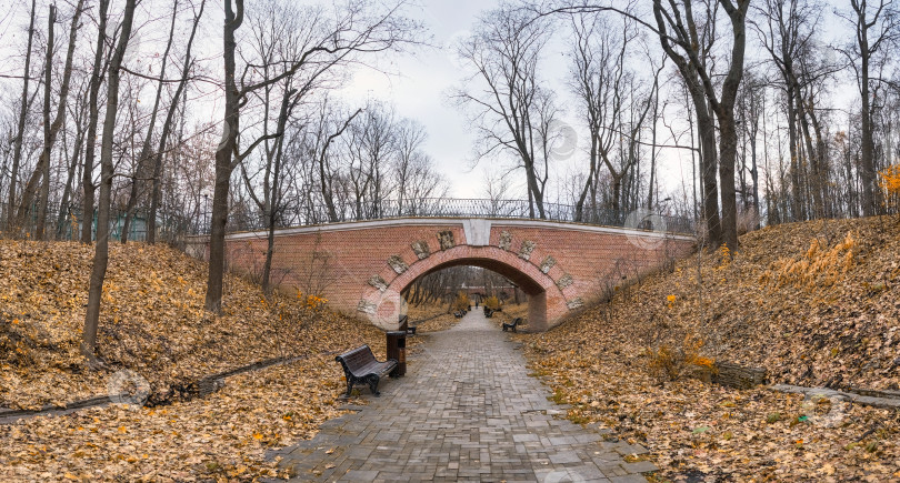 Скачать проход по кирпичному туннелю со скамейками на старинном мосту в городском парке фотосток Ozero