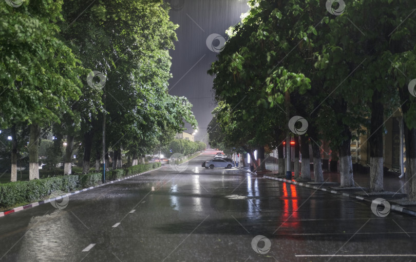 Скачать ночной городской пейзаж под сильным ливнем при свете фонарей фотосток Ozero