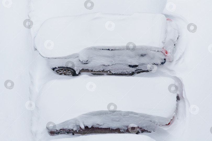 Скачать Машины, занесенные снегом, на парковке. Вид сверху. фотосток Ozero