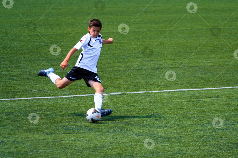 Скачать Москва, Россия, июнь 2018 года: Футбольный матч, молодой игрок делает замах перед ударом по мячу (редакционная статья) фотосток Ozero