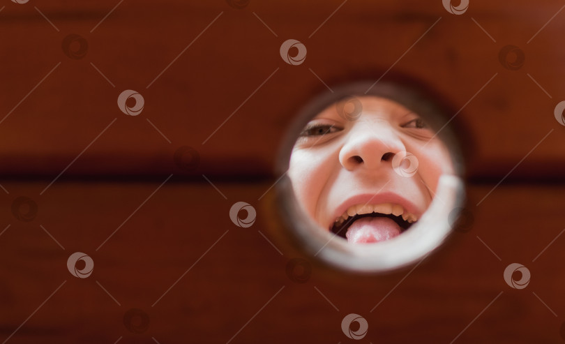 Скачать Вид маленького мальчика через дыру в деревянном заборе фотосток Ozero