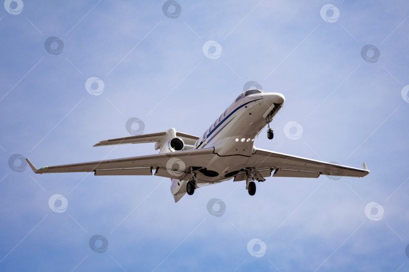 Скачать Легкий бизнес-джет летит в облачном небе фотосток Ozero