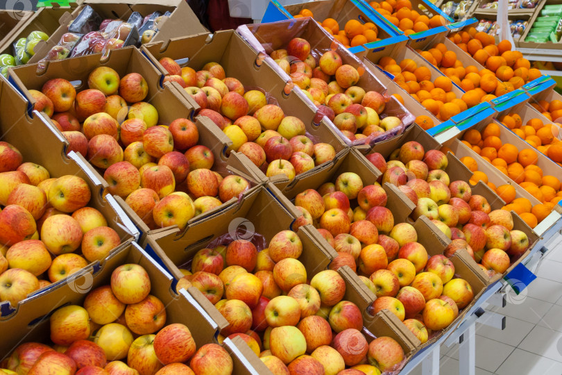 Скачать Ряды картонных коробок с яблоками и апельсинами в супермаркете фотосток Ozero