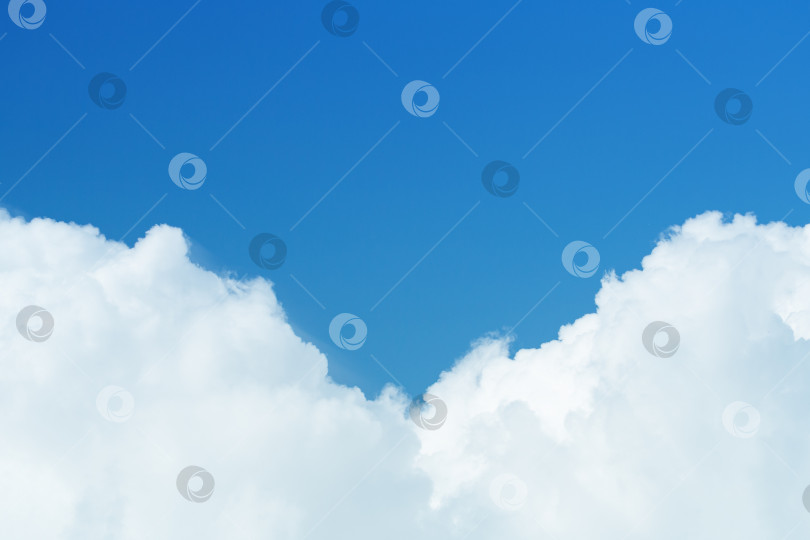 Скачать Крупный план белых кучевых пушистых облаков на фоне ярко-голубого неба с пространством для копирования (фон) фотосток Ozero